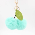 Close-up of mint green plush cherry keychain with leather leaf and golden metal clasp - 8cm Faux Rabbit Fur / Mint Green