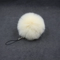 Detail of soft cream faux fur pompom keychain with a black braided cord attachment - 8cm Faux Fur + Strap / Beige