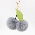 Détail d'un porte-clés cerise en peluche grise avec feuille verte et fermoir doré chic - 8cm Fausse Fourrure de Lapin / Gris clair