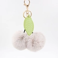 Détail d'un porte-clés cerise en fausse fourrure rose avec feuilles en cuir vert et fermoir doré - 8cm Fausse Fourrure de Lapin / Gris clair