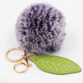 Detailed view of purple faux fur ball keychain with green leaf and gold metal clip - Two-tone Purple