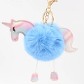 Detailed close-up of a blue faux fur unicorn pompom keychain with golden metal hardware - Light Blue