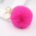 Detailed close-up of rose red faux fur pompom keychain with golden metal lobster clasp - Rose Red