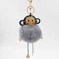 Detailed shot of grey faux fur monkey keychain with black leather head and gold clasp - 8cm / Dark Gray
