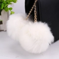 White double faux rabbit fur pom pom keychain with gold chain on a black leather handbag - 8cm / White