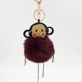 Detail showing plush monkey keychain with burgundy faux fur and golden lobster clasp - 8cm / Purplish Red