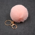 Gros plan du porte-clés pompon en fausse fourrure rose avec mousqueton doré brillant - Boule de Poils 8cm + Fermoir Doré / Rose