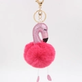 Détail d'un porte-clés flamant rose avec sequins et pompon en fourrure synthétique - Rose rouge