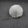 Close-up of fluffy white faux fur pom-pom charm with silver lobster clasp and strap - 8cm Faux Fur + Strap / Gray
