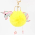 Close-up of bright yellow fluffy unicorn keychain with golden metal clasp and iridescent wings - Yellow