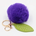 Detail of purple faux rabbit fur ball keychain with green leaf and golden metal clasp - Purple