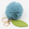 Detail of blue faux rabbit fur pompom with green leather leaf and gold metal keychain - Teal