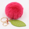 Detail of rose pink faux fur ball keychain with green leaf charm and gold lobster clasp - Rose Red