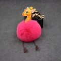 Macro view of cartoon giraffe plush pom pom keychain with pink fur and golden clasp - 8cm Faux Rabbit Fur / Rose Red