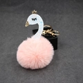 Close-up of pink fluffy swan keychain with glitter details and golden crown accessory - Pink