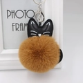 Detail of a fluffy faux fur keychain with a black PU leather cat head and silver metal hook - 8cm Faux Rabbit Fur / Coffee