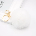 Detail of white faux fur pompom keychain with golden metal lobster clasp and key ring - White
