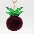 Detailed macro view of plush burgundy pineapple keychain with sparkly green leaves - Fuschia
