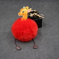 Detail of red giraffe pompom keychain with golden metal lobster clasp and decorative plush ball - 8cm Faux Rabbit Fur / Red