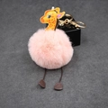 Detailed view of a pink plush pompom giraffe keychain with golden metal alloy clip accessory - 8cm Faux Rabbit Fur / Pink