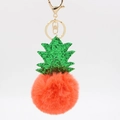 Macro detail of pineapple plush keychain with orange faux fur ball and green sequins - Orange Red