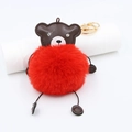 Detailed close-up of bright red faux fur bear keychain with crystal eyes and gold clasp - Red