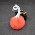 Detail of creative swan plush keychain featuring orange fur pompom and golden crown - Orange Red