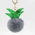 Close-up of a grey faux fur pineapple keychain with green sequins and gold hardware - Dark Gray