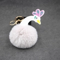 Gros plan d'un porte-clés pompon en forme de cygne avec anneau en métal doré brillant - 8cm Fausse Fourrure de Lapin / Gris clair