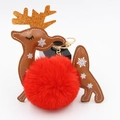 Close-up of a Christmas reindeer plush ball keychain with golden antlers and red faux fur - Red