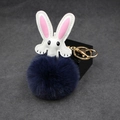 Detail of white leather rabbit charm with navy faux fur pompom and golden keyring - Navy Blue
