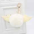 Detail of soft faux fur pompom with angel wings and golden metal lobster clasp - Faux Rabbit Fur / Off White