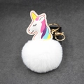 Dettaglio di un ciondolo unicorno in peluche con grande pompon bianco e gancio dorato - 8cm / Bianco