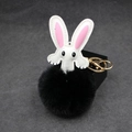Detail of cute rabbit plush keychain featuring black pompom and gold metal clasp - Black