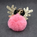 Dettaglio portachiavi pompon in pelliccia rosa con corna di renna dorate glitterate e gancio - Pompon da 8 cm / Rosa Intenso