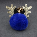 Detailed view of navy blue faux fur pompom keychain with golden sequin reindeer antlers - 8cm Pompom / Sapphire Blue