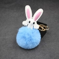 Close-up of blue pompom bunny keychain with white faux leather ears and golden clasp - Light Blue