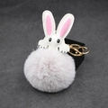 Close-up of cute white rabbit plush keychain with grey faux fur pompom and golden metal clasp - Light Gray