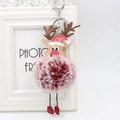 Macro detail of Christmas reindeer plush ball keychain with metal clasp and antler design - Dual-color Red