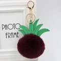 Macro detail of wine red faux fur pineapple pom-pom keychain with green PU leaves - 8cm / Purplish Red