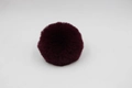 Close-up of fluffy burgundy faux rabbit fur pom pom with dense and soft texture detail - 8cm Faux Rex Rabbit Ball / Purplish Red