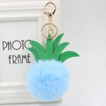 Detail of light blue faux fur pineapple keychain with green PU leather leaves and gold clasp - 8cm / Light Blue