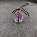 Primer plano del colgante ovalado de resina con árbol de flores secas y hilo de bronce - Estilo árbol violeta