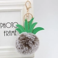 Close-up of fluffy pineapple pom-pom keychain with green leaves and gold metal hook - 8cm / Two-tone Grey