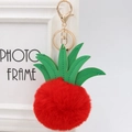 Close-up of red pineapple plush keychain with green leather leaves and gold clasp - 8cm / Red