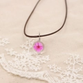 Détail macro du pendentif globe en résine avec une véritable fleur séchée rose incluse - Rouge Rose