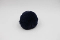 Detailed view of dense texture and soft fur on a dark blue faux fur pom-pom ball - 8cm Faux Rex Rabbit Ball / Navy Blue