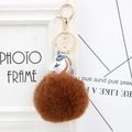 Detail of colorful unicorn leather charm with fluffy brown fur pompom and gold keychain - Brown