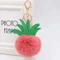 Close-up of pink faux fur pineapple keychain with green PU leaf and golden clasp - 8cm / Bean Paste Red