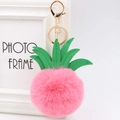 Close-up of pink fur pompom pineapple keychain with green leather leaves and gold clasp - 8cm / Watermelon red